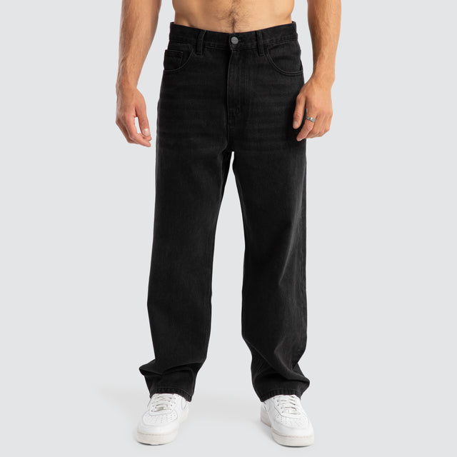 Model Wears Drive Athletic Baggy Jean Black Pants in Black - Image 6