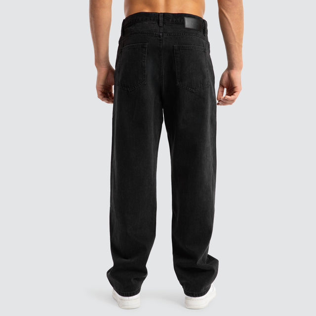 Model Wears Drive Athletic Baggy Jean Black Pants in Black - Image 7