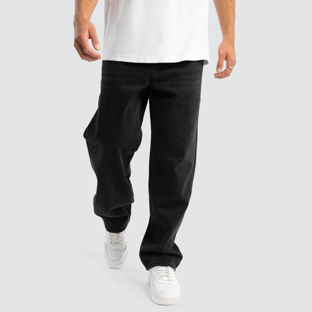 Model Wears Drive Athletic Baggy Jean Black Pants in Black - Image 5