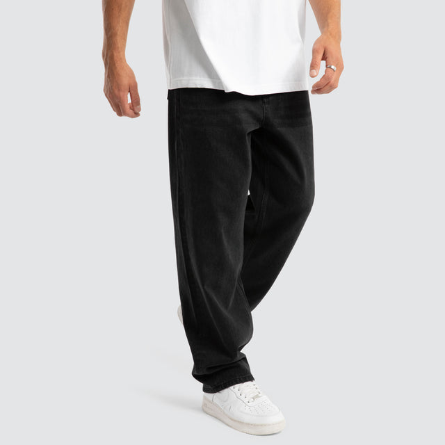 Model Wears Drive Athletic Baggy Jean Black Pants in Black - Image 1