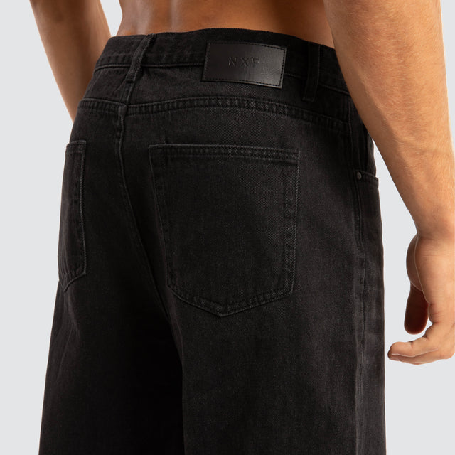 Model Wears Drive Athletic Baggy Jean Black Pants in Black - Image 4