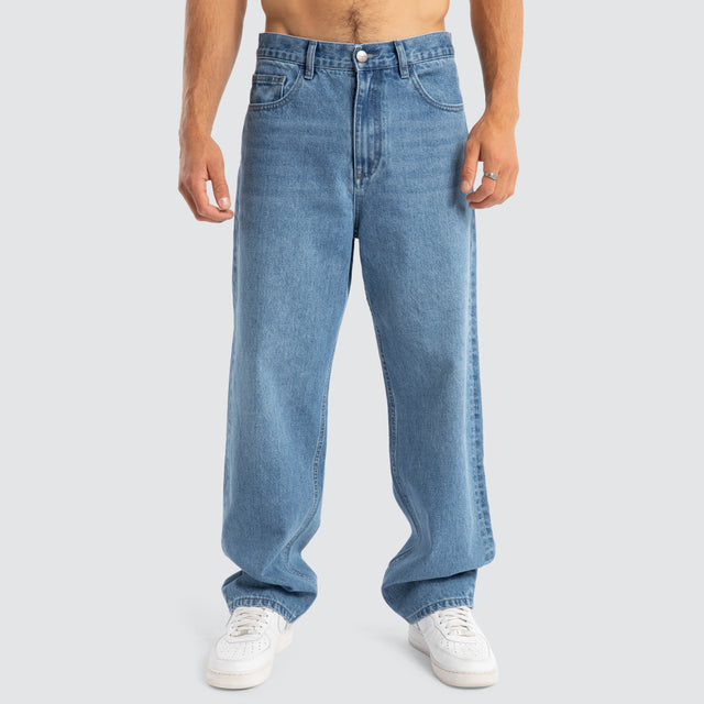 Model Wears Drive Athletic Baggy Jean Washed Blue Pants in Blue - Image 5