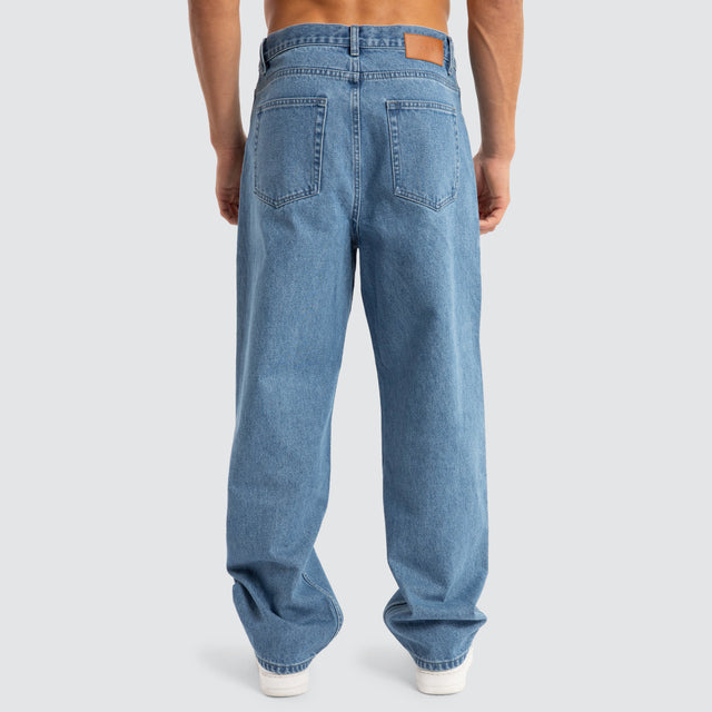Model Wears Drive Athletic Baggy Jean Washed Blue Pants in Blue - Image 6