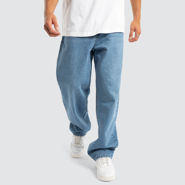 Model Wears Drive Athletic Baggy Jean Washed Blue Pants in Blue - Image 7