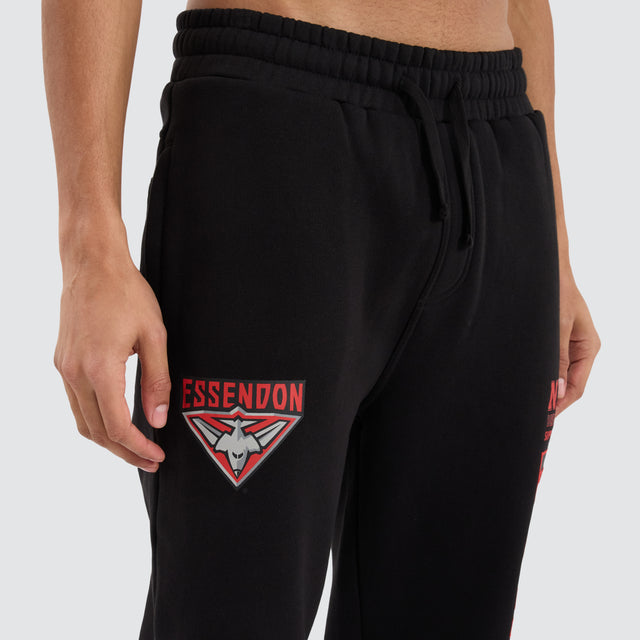 Model Wears Essendon Bombers AFL Trackpant Jet Black Trackpants in Black - Image 2