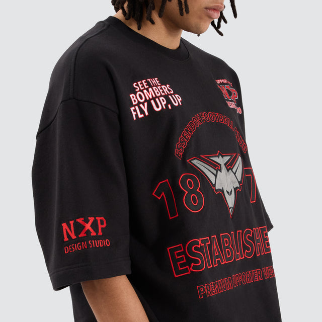 Model Wears Essendon Bombers AFL Mega Loopback Tee Jet Black T-Shirts in Black - Image 2