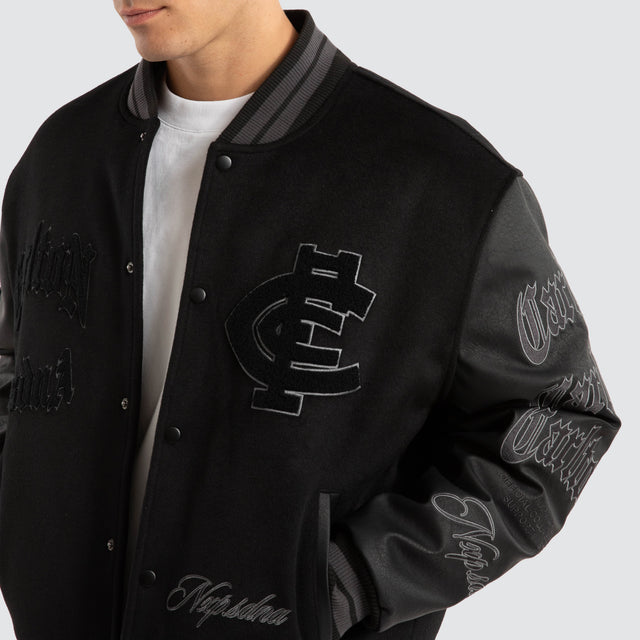 Model Wears Carlton Blues AFL Ace Varsity Jacket Jet Black Jackets in Black - Image 3