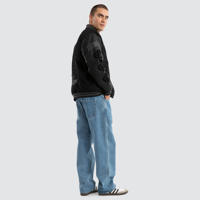 Model Wears Carlton Blues AFL Ace Varsity Jacket Jet Black Jackets in Black - Image 4