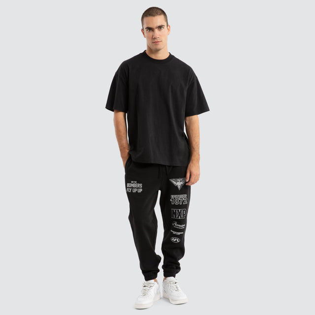 Model Wears Essendon Bombers AFL Mono Trackpants Jet Black Trackpants in Black - Image 2