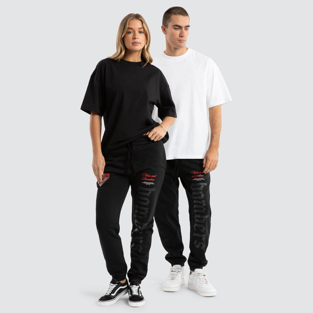 Model Wears Essendon Bombers AFL Cali Trackpants Jet Black Trackpants in Black - Image 2