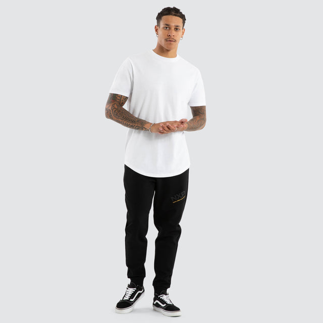 Model Wears Turret Slim Trackpant Jet Black Trackpants in Black - Image 2