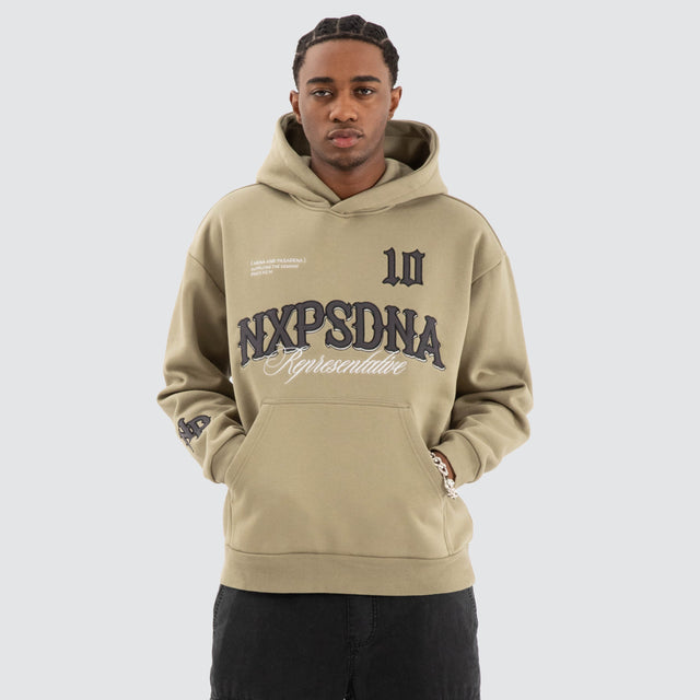 Model Wears Warrior Relaxed Hoodie Khaki Green Hoodies in Green - Image 1