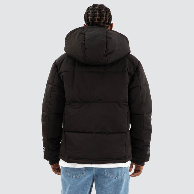 Model Wears Burden Hooded Puffer Jet black Jackets in Black - Image 3