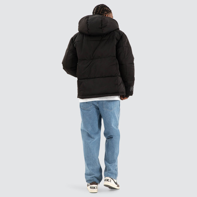 Model Wears Burden Hooded Puffer Jet black Jackets in Black - Image 4