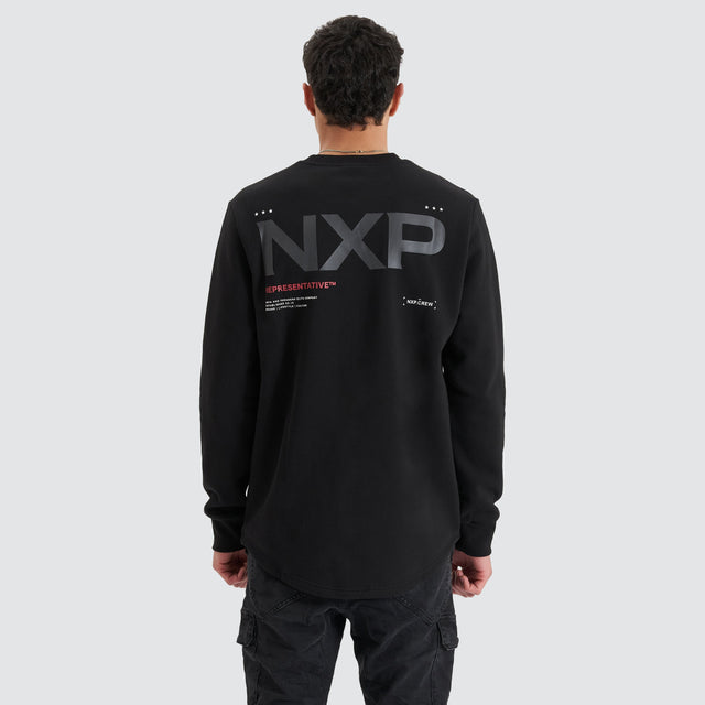 Model Wears Adjacent Dual Curved Sweater Jet Black Jumpers in Black - Image 2