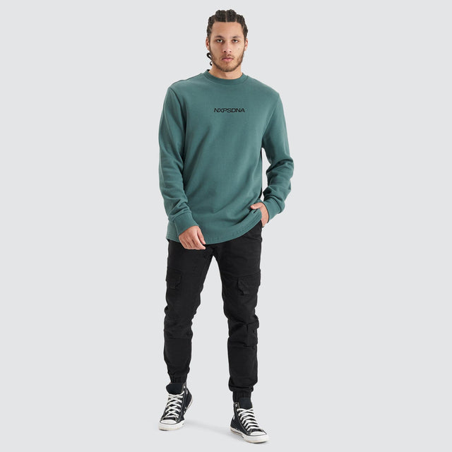 Model Wears Compensation Dual Curved Jumper Silver Pine/Black Jumpers in Green - Image 3