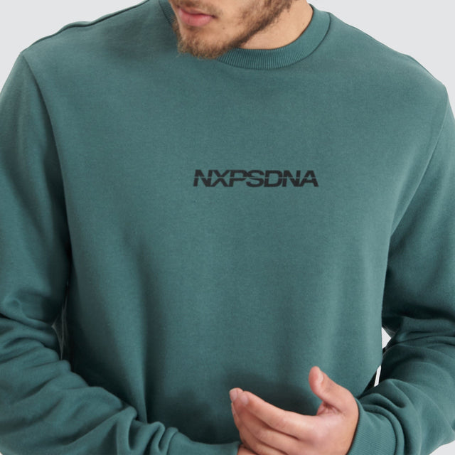 Model Wears Compensation Dual Curved Jumper Silver Pine/Black Jumpers in Green - Image 2