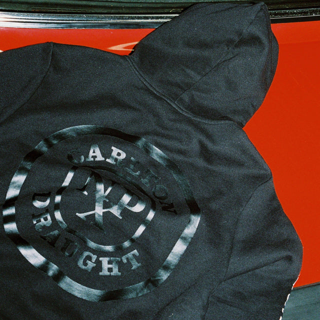 Model Wears Drummond Dual Curved Hoodie Jet Black Hoodies in Black - Image 2