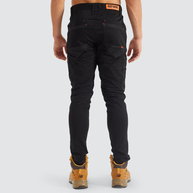 Model Wears Precision Slim Fit Pant Black Pants in Black - Image 9