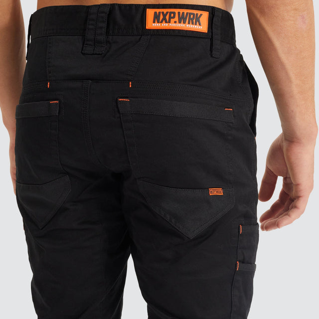 Model Wears Precision Slim Fit Pant Black Pants in Black - Image 10