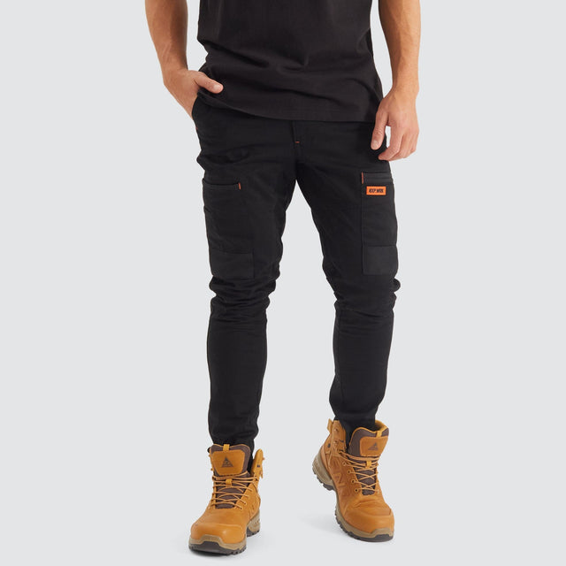 Model Wears Precision Slim Fit Pant Black Pants in Black - Image 1