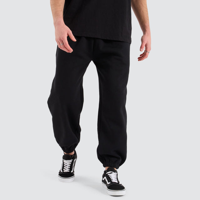 Model Wears Supply Baggy Sweat Pant Jet Black Trackpants in Black - Image 1