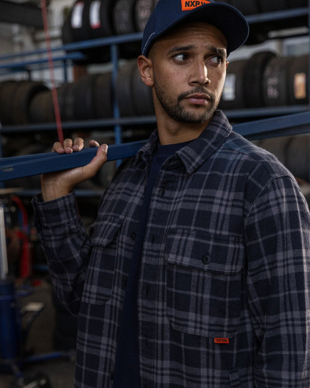 Layered workwear outfit with flannel shirt, work tee and cap 