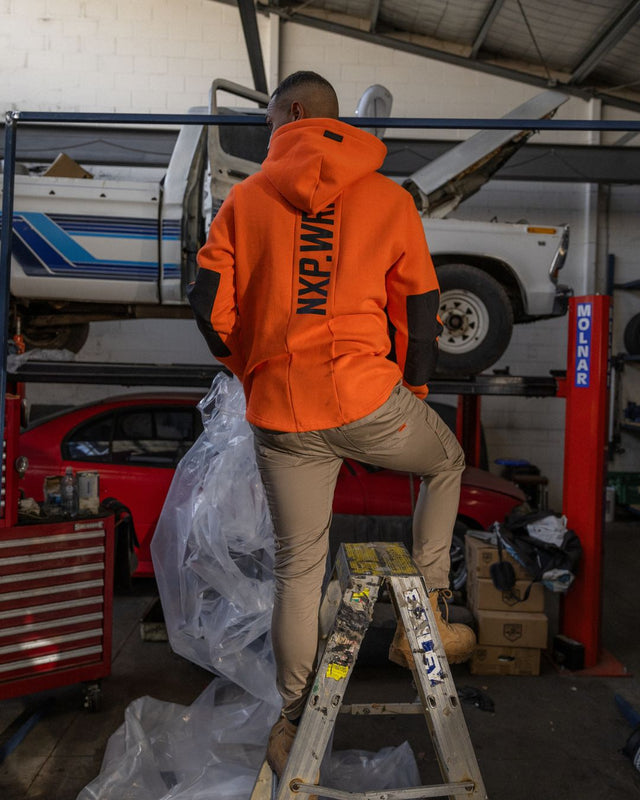 The complete winter workwear outfit, this welder is wearing the NXP. orange workwear hoodie with tan coloured slim fit workwear pants