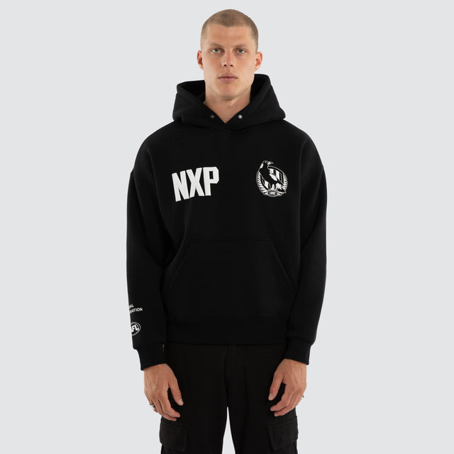 Model wears Collingwood Magpies AFL Top Tier Hoodie Jet Black Hoodies in Black - Image 5