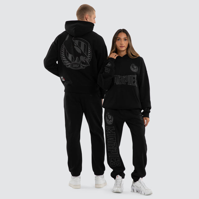 Model wears Collingwood Magpies AFL Persistent Hoodie Jet Black Hoodies in Black - Image 4