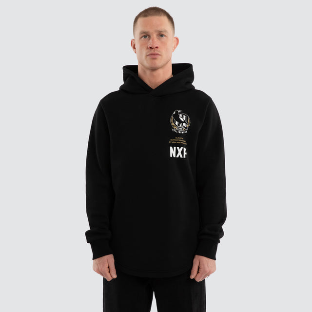 Model wears Collingwood Magpies AFL Trophy Curved Hem Hoodie Jet Black Hoodies in Black - Image 2
