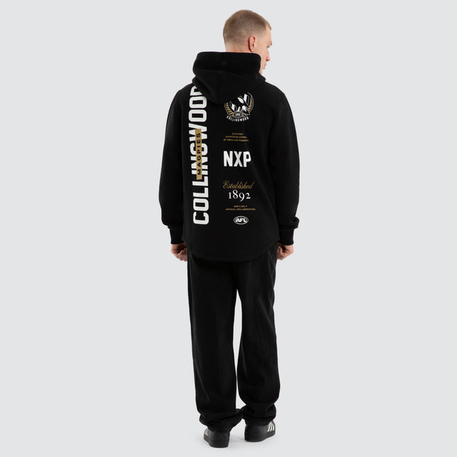 Model wears Collingwood Magpies AFL Trophy Curved Hem Hoodie Jet Black Hoodies in Black - Image 4