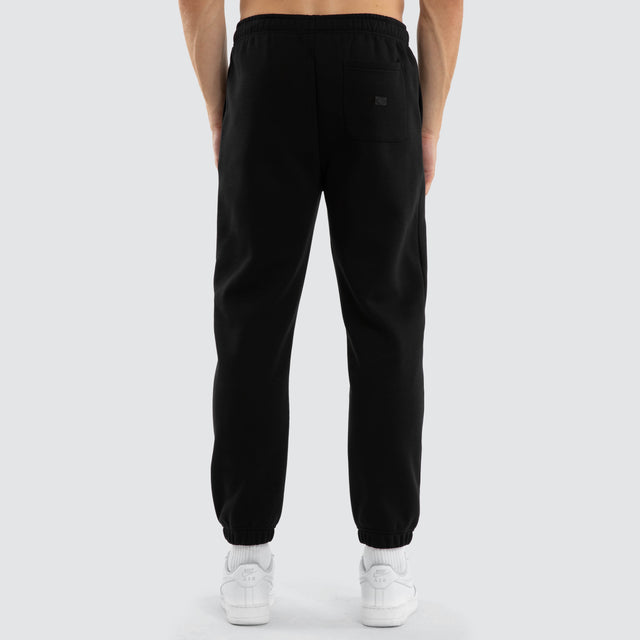 Model wears Collingwood Magpies AFL Perform Trackpant Jet Black Trackpants in Black - Image 6