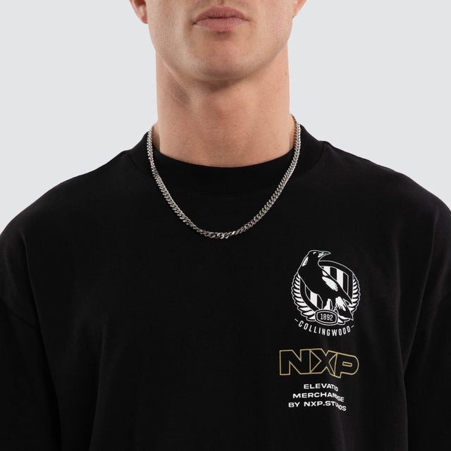Model wears Collingwood Magpies AFL Sticker Raptor Tee Jet Black T-Shirts in Black - Image 5