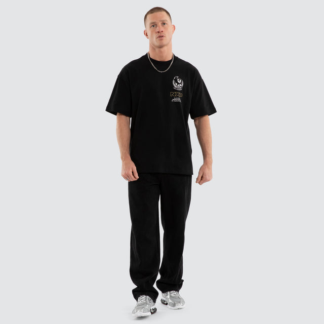 Model wears Collingwood Magpies AFL Sticker Raptor Tee Jet Black T-Shirts in Black - Image 7