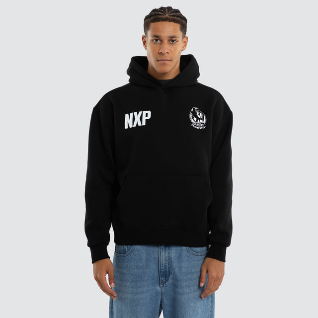 Model wears Collingwood Magpies AFL Champions Box Hoodie Jet Black Hoodies in Black - Image 1