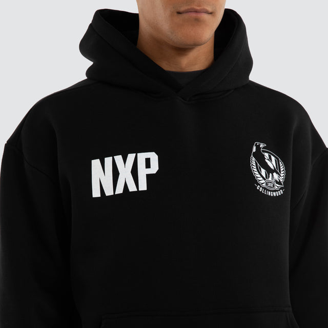 Model wears Collingwood Magpies AFL Champions Box Hoodie Jet Black Hoodies in Black - Image 3