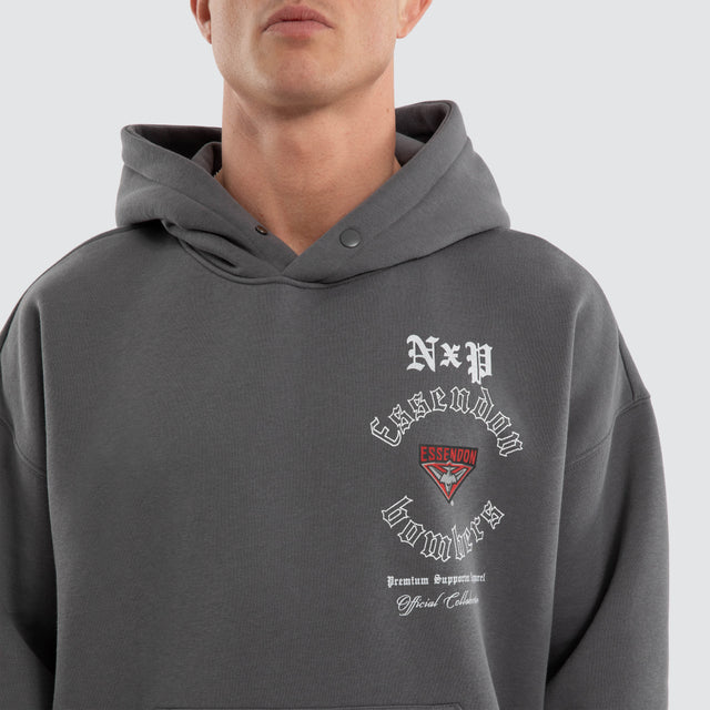 Model wears Essendon Bombers AFL Tag Box Fit Hoodie Charcoal Hoodies in Grey - Image 3