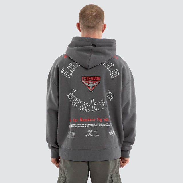 Model wears Essendon Bombers AFL Tag Box Fit Hoodie Charcoal Hoodies in Grey - Image 1