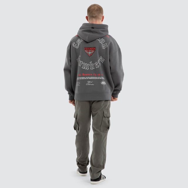 Model wears Essendon Bombers AFL Tag Box Fit Hoodie Charcoal Hoodies in Grey - Image 6
