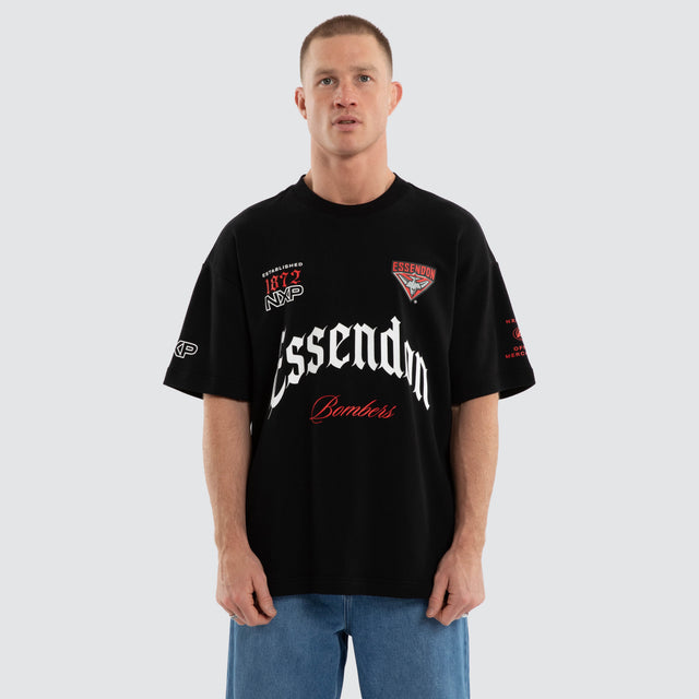 Model wears Essendon Bombers AFL Gold Raptor Tee Jet Black T-Shirts in Black - Image 4