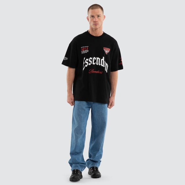Model wears Essendon Bombers AFL Gold Raptor Tee Jet Black T-Shirts in Black - Image 7