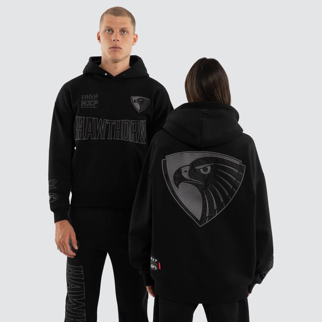Model wears Hawthorn Hawks AFL Persistent Hoodie Jet Black Hoodies in Black - Image 1