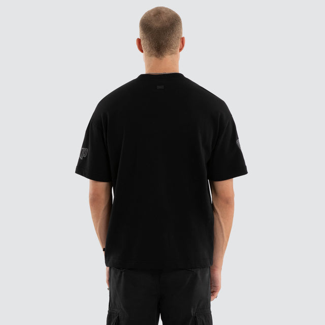 Model wears Hawthorn Hawks AFL Perform Loopback Tee Jet Black T-Shirts in Black - Image 3