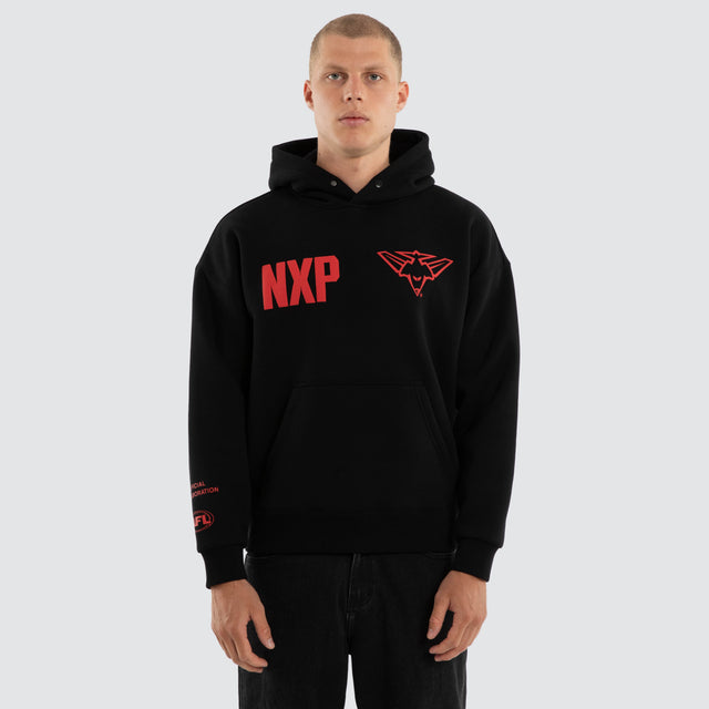 Model wears Essendon Bombers AFL Top Tier Hoodie Jet Black Hoodies in Black - Image 4