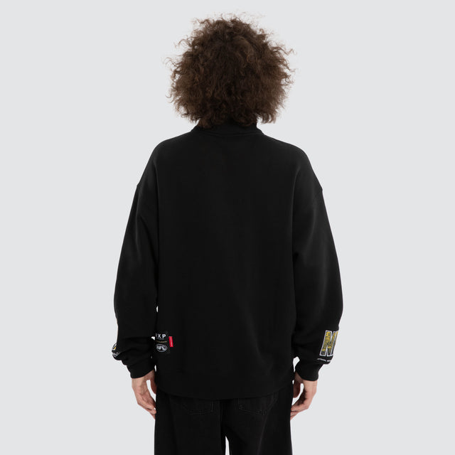 Model wears Ben Davis Richmond Tigers AFL 1/4 Zip Thru Jet Black Pullover in Black - Image 5