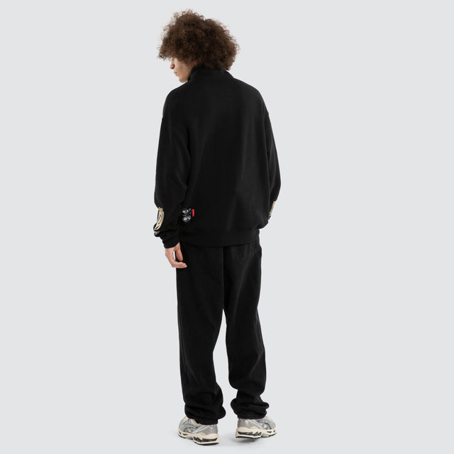Model wears Ben Davis Richmond Tigers AFL 1/4 Zip Thru Jet Black Pullover in Black - Image 7