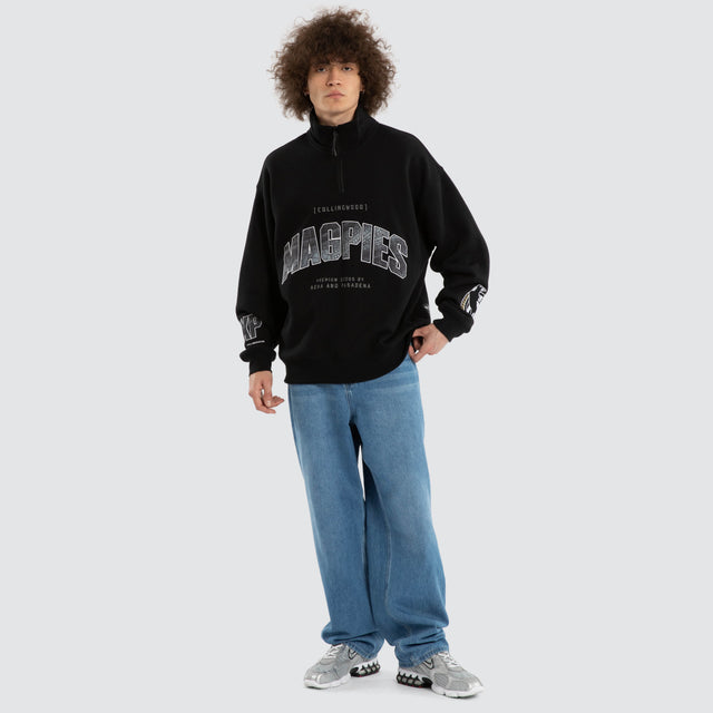 Model wears Ben Davis Collingwood Magpies AFL 1/4 Zip Thru Jet Black Pullover in Black - Image 7
