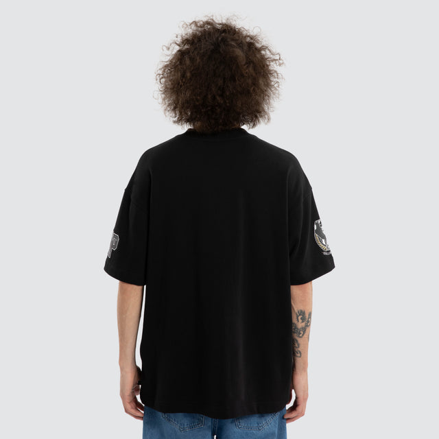 Model wears Ben Davis Collingwood Magpies AFL Loopback Raptor Jet Black T-Shirts in Black - Image 3