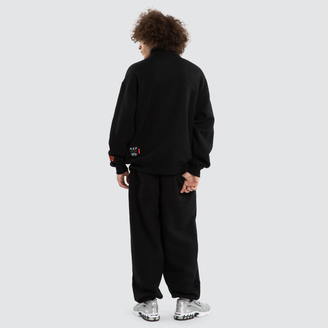Model wears Ben Davis GWS Giants AFL 1/4 Zip Thru Jet Black Pullover in Black - Image 7